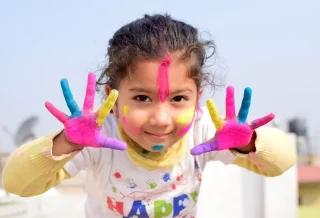 une enfant avec de la peinture sur les mains