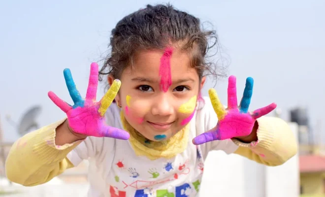 une enfant avec de la peinture sur les mains